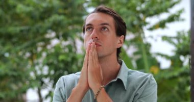 İnanç ve din kavramı. Yakışıklı, düşünceli, Avrupalı bir Hıristiyan arka planda Tanrı 'ya dua ediyor.