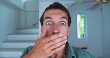 Yakışıklı beyaz adam, yüzünü ve ağzını kapatıyor. Gördüklerinden korkuyor, korku ve korku hissediyor.