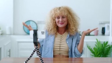Çekici kadın, başarılı blogger vlog kaydedicisi blogu için bir video içeriği kaydediyor, akıllı telefonu tripoda bağlı olarak kullanıyor