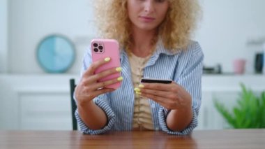 Seçici odak noktası kredi kartı tutan, akıllı telefon kullanan, çevrimiçi nakitsiz ödemeler yapan kadınların elleri.