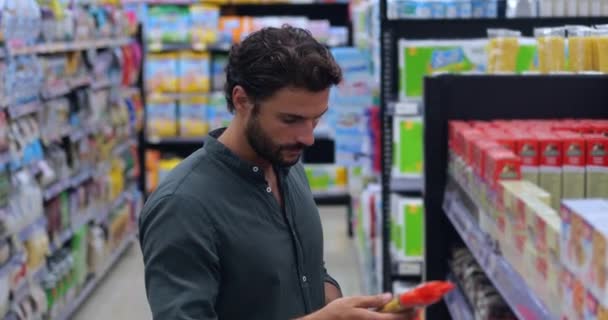 Guapo Joven Comprador Compras Comestibles Supermercado Tomando Espaguetis Estante Pie — Vídeo de stock