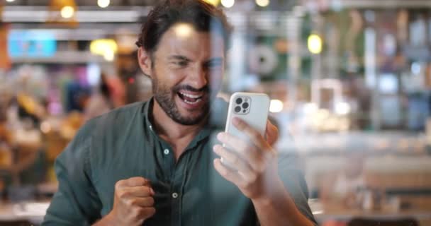 Bekijk Door Een Cafe Ramen Naar Een Man Met Smartphone — Stockvideo
