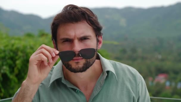 Привлекательный Латиноамериканец Смотрит Сквозь Свои Опущенные Солнцезащитные Очки Выражая Удивление — стоковое видео