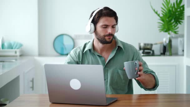 Joven Guapo Con Auriculares Inalámbricos Bebiendo Bebida Caliente Taza Mientras — Vídeos de Stock