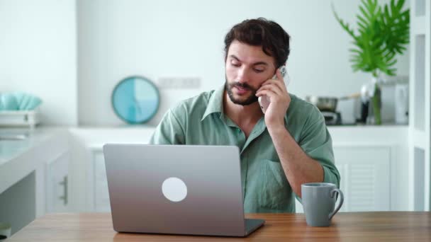 Homem Bonito Sorridente Tem Conversa Telefônica Casa Usando Laptop Enquanto — Vídeo de Stock