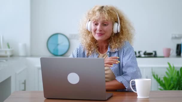 Mujer Guapa Caucásica Pone Auriculares Audio Saluda Interlocutor Mientras Hace — Vídeo de stock