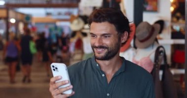 Heyecanlı adam, lüks moda mağazasından yeni kıyafetler alırken tasarruf etmek için internetten mağazalardan daha ucuza alışveriş yapıyor.