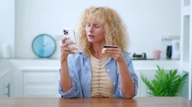Avrupalı sarışın kadın akıllı telefon ve internet bankacılığı kullanarak online ödeme yapıyor, ödemeyi yapamadığı halde kızgınlığını dile getiriyor