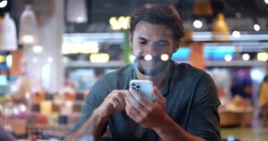 Çekici beyaz sakallı maço adam cep telefonu kullanıyor, haber akışını kaydediyor, sosyal medya içeriğini kontrol ediyor, internette sohbet ediyor.