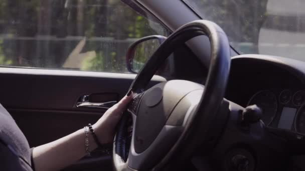 Video, woman hands drive a automobile, beautiful fingers lie on the steering wheel.