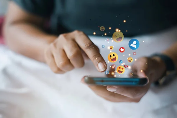 Kadın yatakta yatarken akıllı telefonuyla oynuyor. Asyalı kız yatakta dinleniyor ve cep telefonuyla metaverse oynuyor.. 