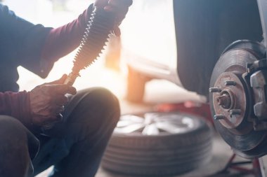 Arabaya seçici odaklı disk freni, yeni lastik değiştirme işlemi, garajda araba freni tamiri.