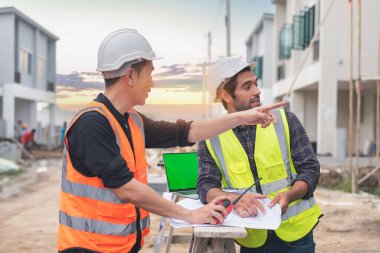 İnşaat alanında mavi baskı ile çalışan mühendis ve mimar konsepti, inşaat alanında çalışan inşaatlara ustabaşı iş kontrolü.