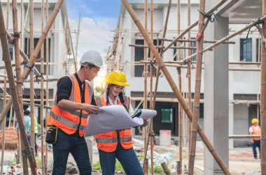 İnşaat alanında mavi baskı ile çalışan mühendis ve mimar konsepti, inşaat alanında çalışan inşaatlara ustabaşı iş kontrolü.