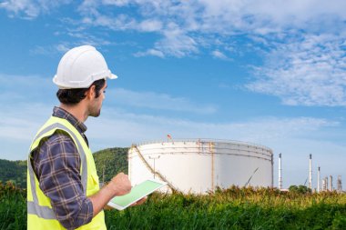 Petrol rafinerisinde tabletle çalışan bakım mühendisi, metin için alanı kopyala.