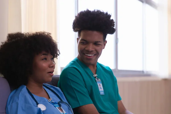 Two black nursing students sit and relax in the hospital after caring for a patient.