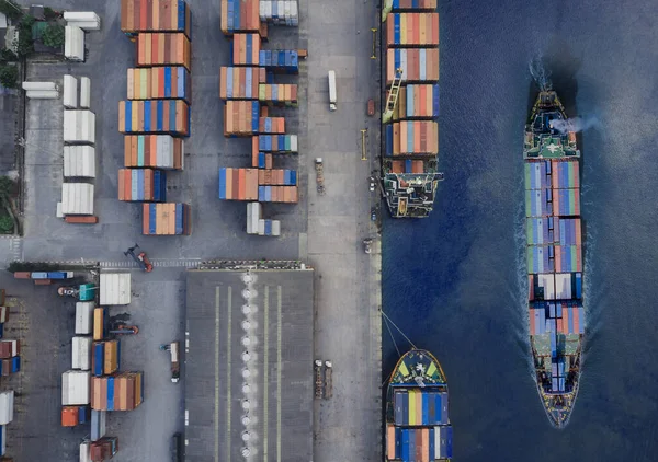 Container ship in export and import business and logistics. Shipping cargo to harbor by crane. Water transport International. Aerial view of drone.