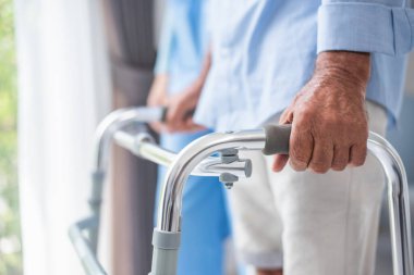 Yürüyen sakatlık. Yürümeye çalışırken yürütece tutunan bir erkeğin elini kapat..