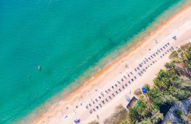 Top View of a Beach in Phuket,Thailand, Kamara Beach  tourists relaxing on the beach, swimming and playing games on a hot summer day.