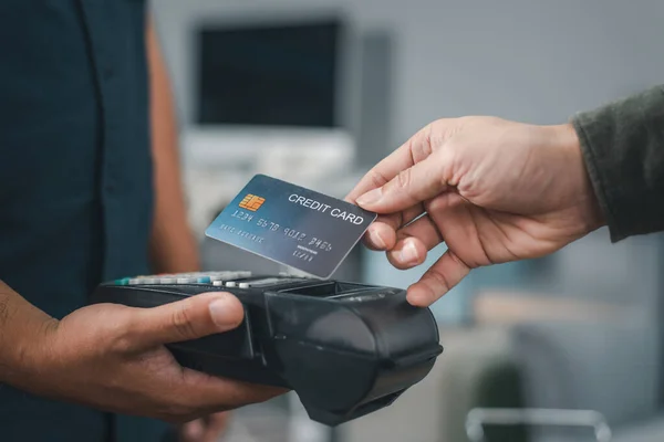 Customer using credit card for payment to owner at cafe restaurant, cashless technology and credit card payment concept