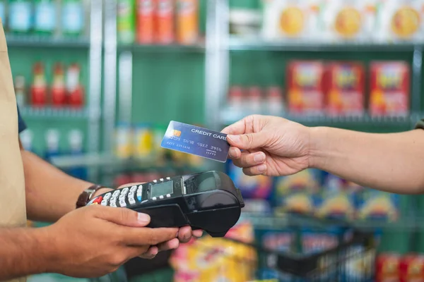 Customer using credit card for payment to owner at cafe restaurant, cashless technology and credit card payment concept