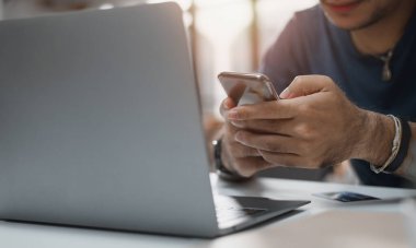 Çevrimiçi bankacılık ağları için akıllı telefonlar ve dizüstü bilgisayarlar tutan eller. Dijital ödemeler online ve online alışveriş. Küresel bir internet ağına bağlanmak için pazarlama ve finans teknolojisi.