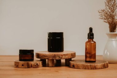 Kozmetik konteynırı ahşap masaya kurulmuş ve gri bej doğal arka plan