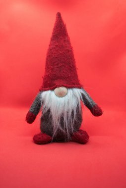 Gri elbiseli, kırmızı şapkalı, beyaz sakallı eski bir Noel cücesi. Kış Tatilleri Geliyor Konsepti. 