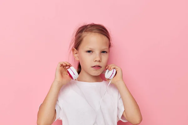 Πορτρέτο του χαρούμενος χαμογελαστό κορίτσι παιδί σε ένα λευκό t-shirt με ακουστικά παιδική ηλικία αναλλοίωτη — Φωτογραφία Αρχείου