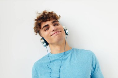 Mavi tişörtlü, sapkın adam kulaklık takan, izole edilmiş arka plan.