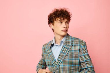 Elleriyle hareket eden genç bir kıvırcık adamın portresi. Duyguları karalanmış ceket, izole edilmiş arka plan değiştirilmemiş.