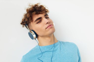 Mavi tişörtlü, sapkın adam kulaklık takan, izole edilmiş arka plan.