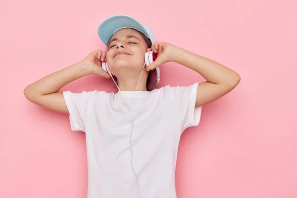 Porträt eines glücklich lächelnden Mädchens, das Musik über Kopfhörer hört, isolierter Hintergrund — Stockfoto