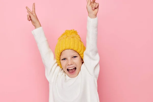 Küçük kız sarı şapkalı eğlenceli bir arka planda — Stok fotoğraf