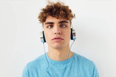 Kulaklık takan yakışıklı bir adam. Duyguları soyutlanmış.