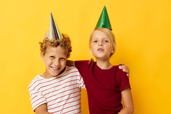 Porträt von niedlichen Kindern in lässiger Kleidung mit Mützen auf dem Kopf auf farbigem Hintergrund — Stockfoto