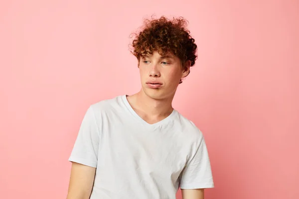 Joven rizado hombre posando estilo joven blanco camiseta rosa fondo inalterado — Foto de Stock