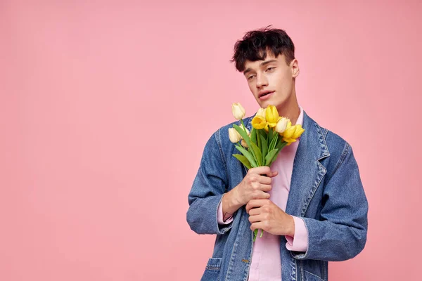 Гарний хлопець букет жовтих квітів подарунок свято елегантний стиль рожевий фон незмінний — стокове фото