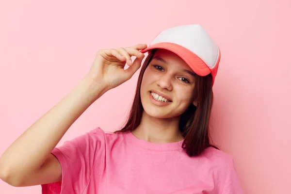Cheerful young girl with a cap on her head in a pink t-shirt — Stockfoto