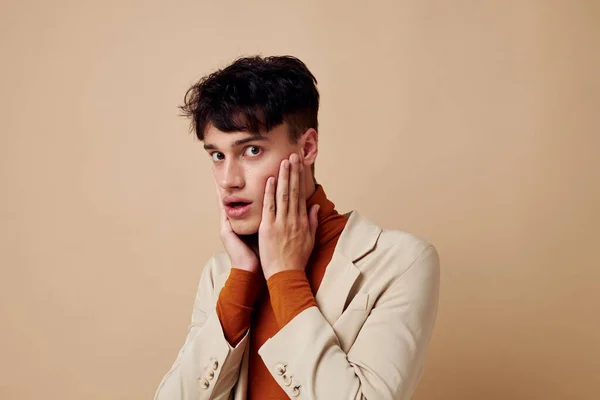 Chico guapo en una chaqueta beige hablando por teléfono aislado fondo inalterado — Foto de Stock