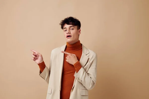 A young man in a beige jacket talking on the phone isolated background unaltered — 스톡 사진