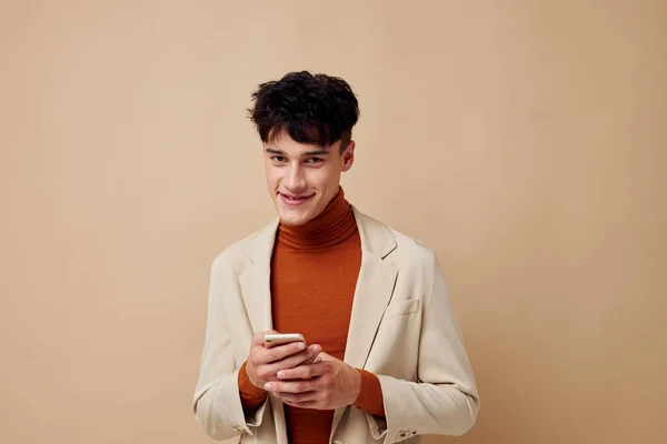 Chico guapo posando con un teléfono en sus manos en una chaqueta de estilo elegante estilo de vida inalterado — Foto de Stock