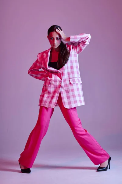 Young beautiful woman luxury clothing fashion plaid blazer pink background unaltered — Zdjęcie stockowe