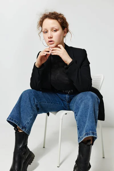 Portrait of a young woman sitting on a chair in a black jacket fashion posing Lifestyle unaltered — ストック写真