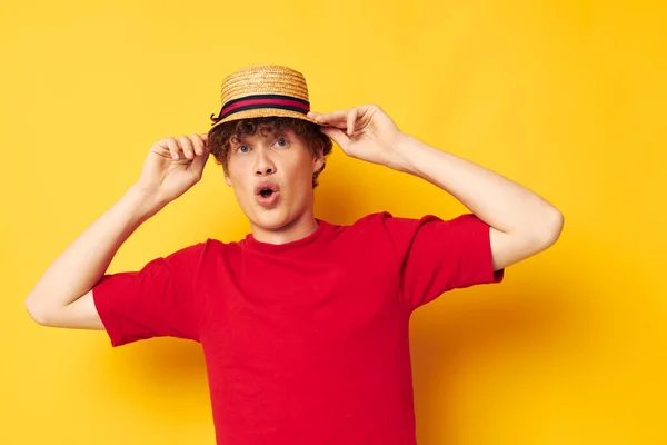 Tipo con el pelo rizado rojo en una camiseta roja con un sombrero de moda fondo amarillo inalterado — Foto de Stock