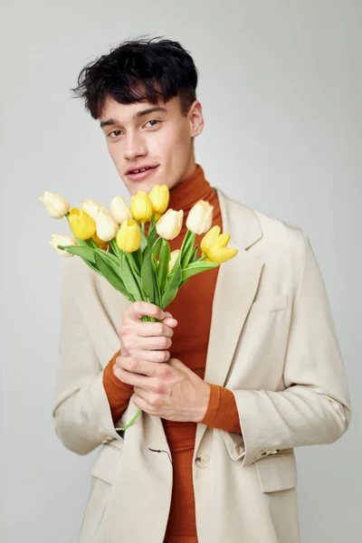 Portrait of a young man bouquet of flowers romance fashion date isolated background unaltered — Stock fotografie