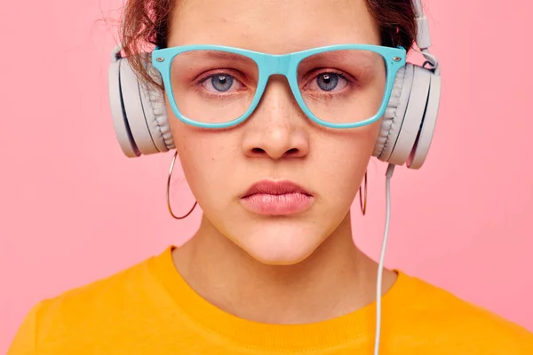 Portrait of a young woman wearing headphones blue glasses close-up emotions cropped view unaltered — Foto de Stock