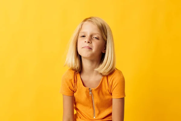 Neşeli küçük kız el hareketi ve eğlenceli sarı arka plan — Stok fotoğraf
