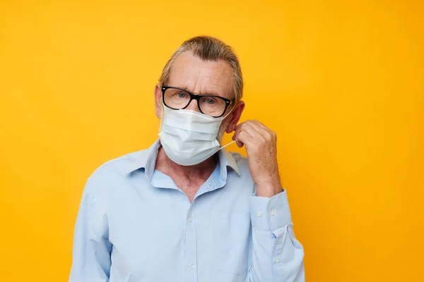 Senior grey-haired man with glasses safety medical mask posing cropped view — Fotografia de Stock