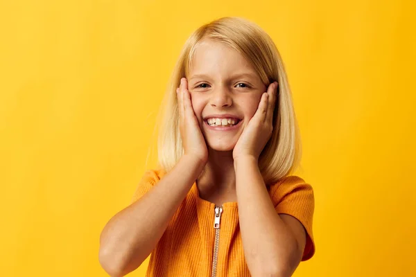 Niedliches kleines Mädchen mit blonden Haaren auf der Grundlage von Kindheit gelb Hintergrund — Stockfoto